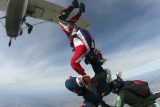 Learn to skydive student exits the airplane with their two instructors