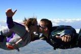 Two licensed skydivers kiss during freefall