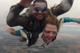 Tandem skydiving pair smiles during freefall
