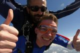 Tandem skydiving students gives two thumbs up in freefall