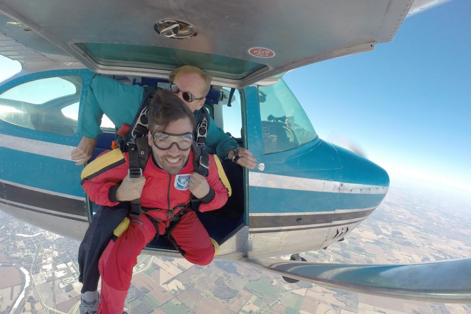 man looks up before exiting skydiving plan