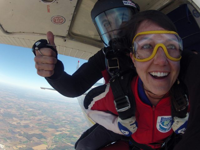woman faces her fears before exiting skydiving plane