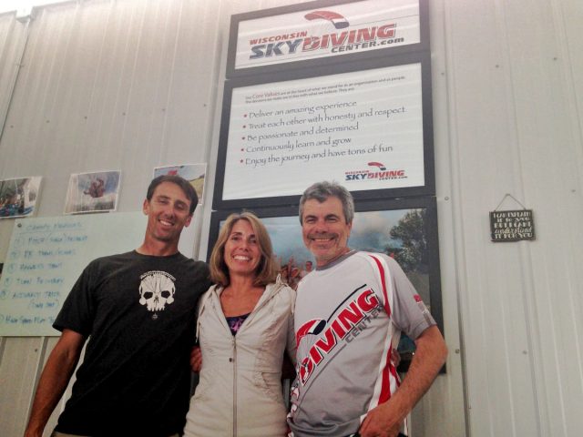 Alex and Bo in front of Wisconsin Skydiving Center Core Values sign