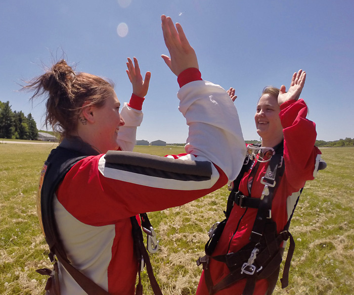 Two solo skydiver high five each other after landing at Wisconsin Skydiving Center near Milwaukee, WI