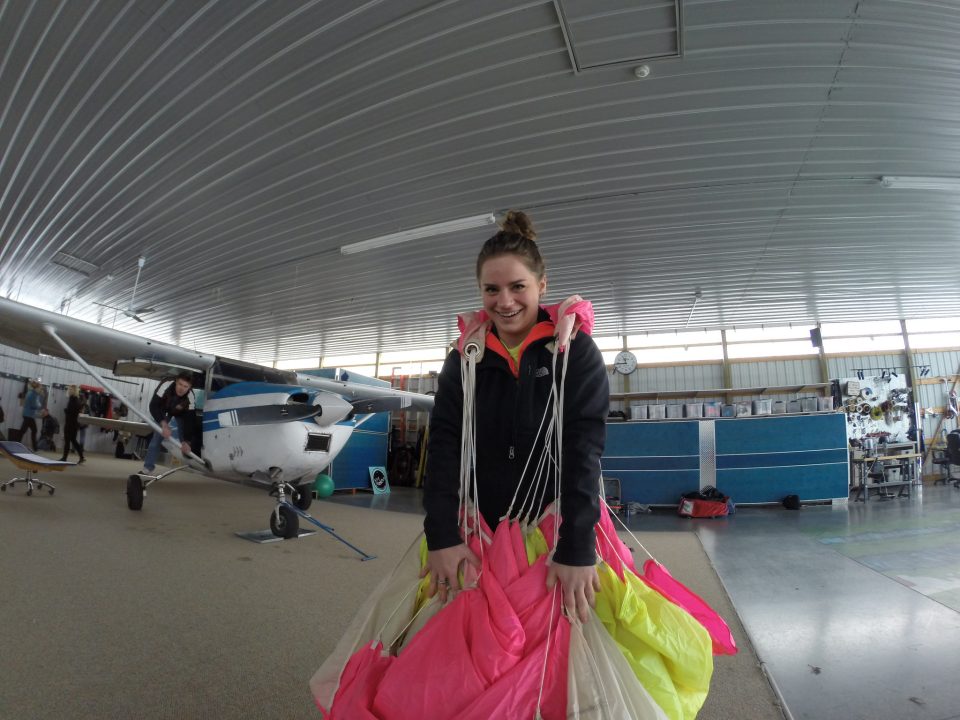 A young lady packing her parachute and preparing for a skydive in the hangar at Wisconsin Skydiving Center