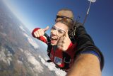 First-time skydiver giving a thumbs up during her tandem skydive at Wisconsin Skydiving Center near Milwaukee