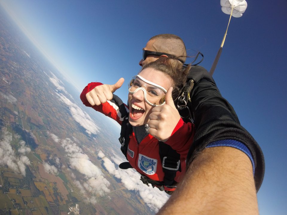 First-time skydiver giving a thumbs up during her tandem skydive at Wisconsin Skydiving Center near Milwaukee