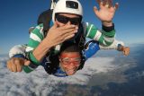Tandem skydiver giving thumbs up and instructor blowing a kiss at Wisconsin Skydiving Center near Milwaukee