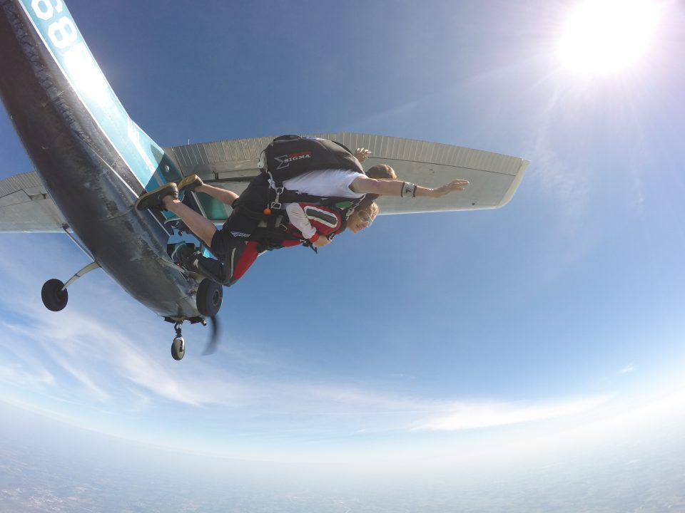 a tandem skydive instructor and student exiting the plane