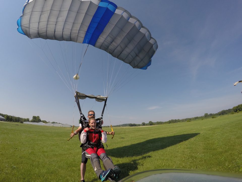 Woman skydiver lifting legs to land after a tandem jump at Wisconsin Skydiving Center near Milwaukee