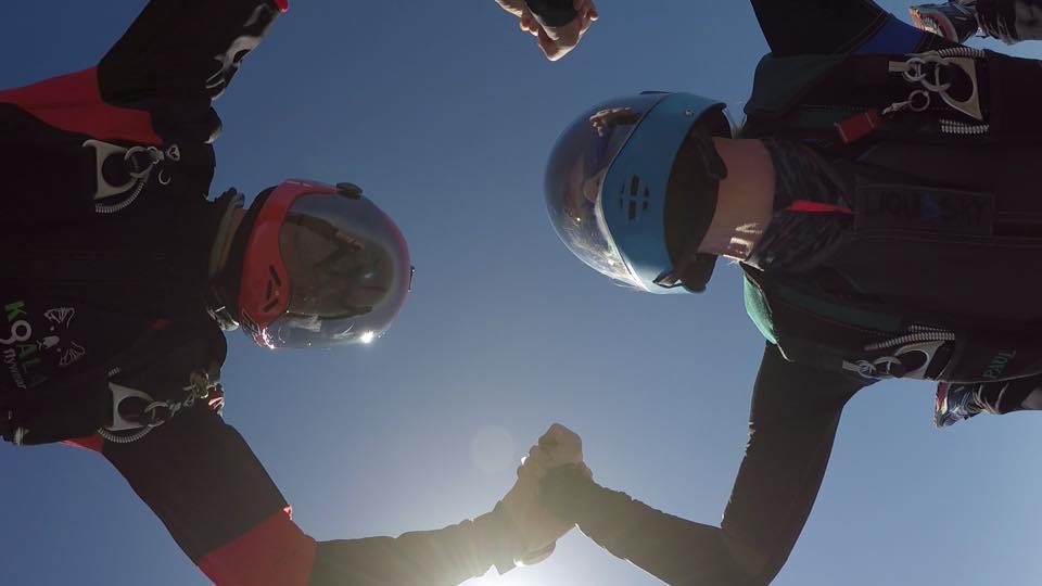 Erica and Tyler holding hands while on a jump
