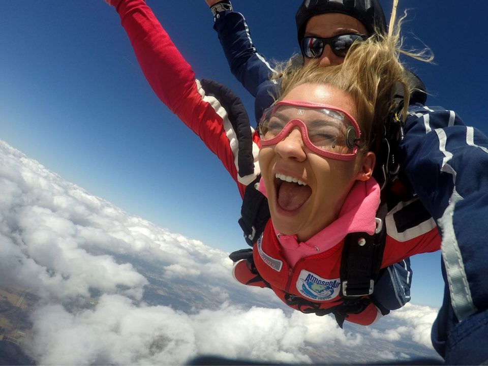 Girl smiles widely while making a tandem skydive at Wisconsin Skydiving Center