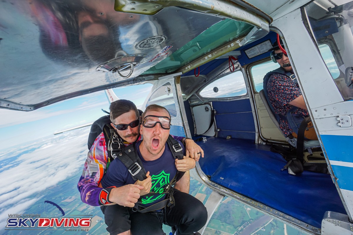 Man jumping into freefall during first tandem skydive at Wisconsin Skydiving Center near Chicago