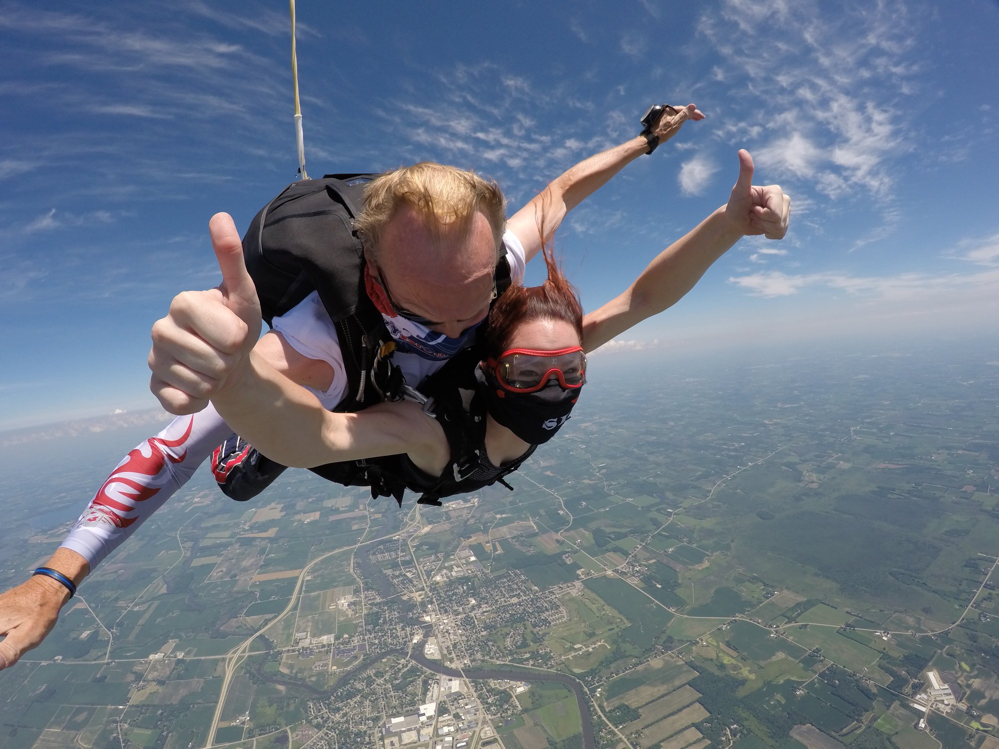 Woman thumbs up in freefall no ear pressure during first tandem skydive at Wisconsin Skydiving Center near Chicago