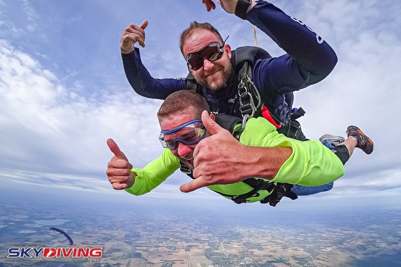 Man giving rock on signs while coasting down at Wisconsin Skydiving Center near Chicago