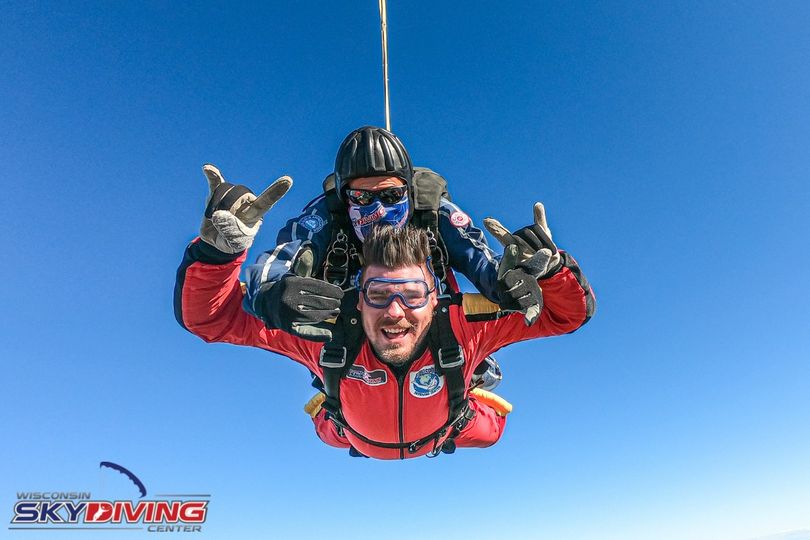 Man giving rock on signs while skydiving down at Wisconsin Skydiving Center near Chicago