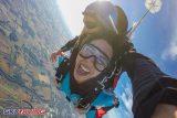 Woman smiling big in freefall tandem skydive after jumping from a plane at Wisconsin Skydiving Center near Chicago