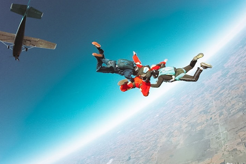Learn to skydive student with their two instructors in freefall
