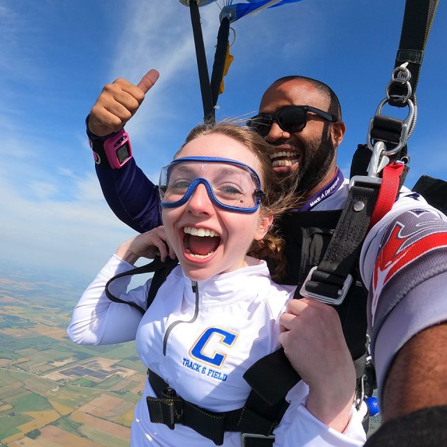 Young female tandem skydiver with her instructor under canopy