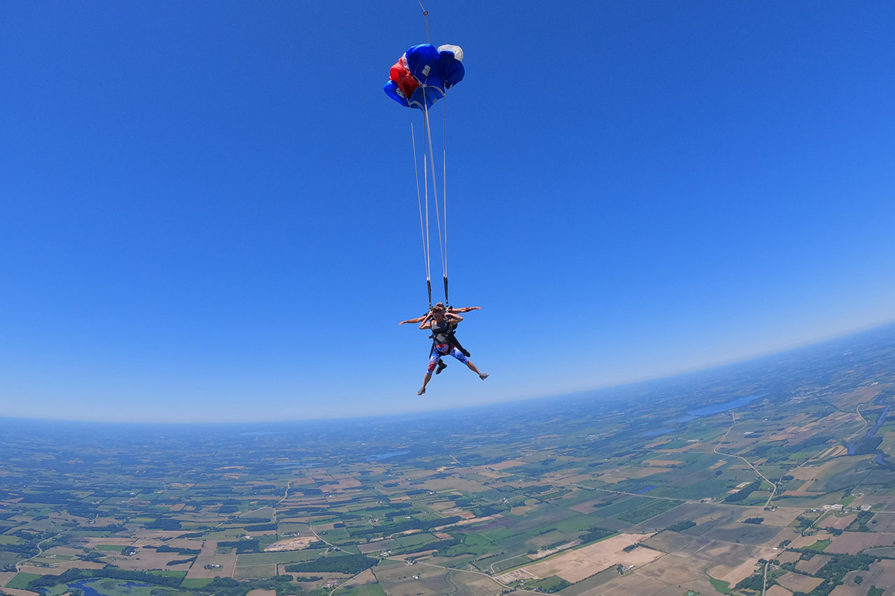 Tandem skydiving pair after parachute deployment