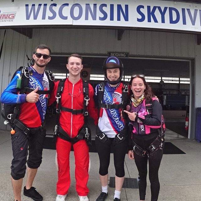 A tandem skydiver, his instructor, and licensed jumpers in the hangar at WSC