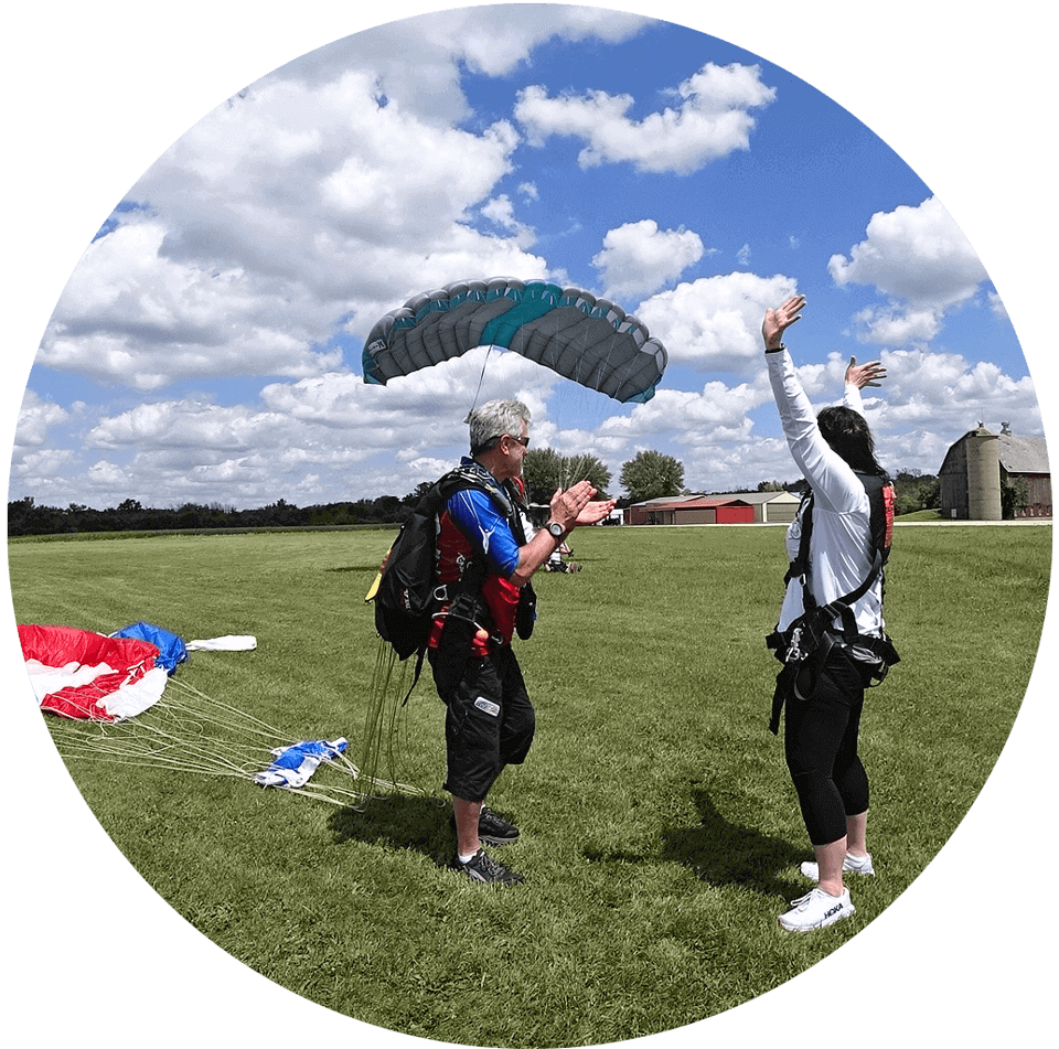 DZO and tandem instructor Bo Babovic clapping after landing from a skydive with his female student.