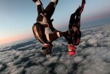 Two licensed skydivers fly head down.