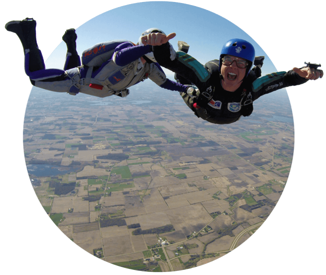 Learn to skydive AFF student and their instructor smile at the camera during freefall.