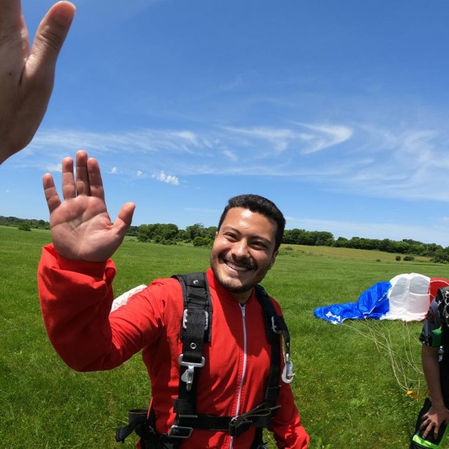 Tandem skydiver gives a high five to the videographer
