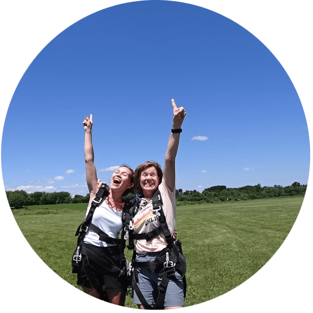 Two female tandem students point to the sky