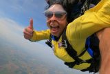 tandem skydiving pair giving a thumbs up