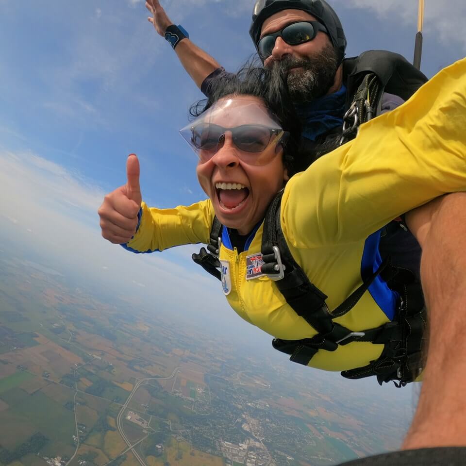 tandem skydiving pair giving a thumbs up