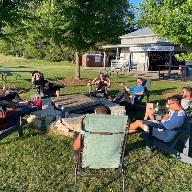 Group of skydivers supporters sitting around the fire pit enjoying the grounds at Wisconsin Skydiving Center