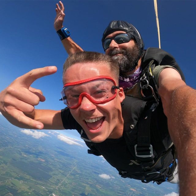 Two men on a tandem skydive smiling